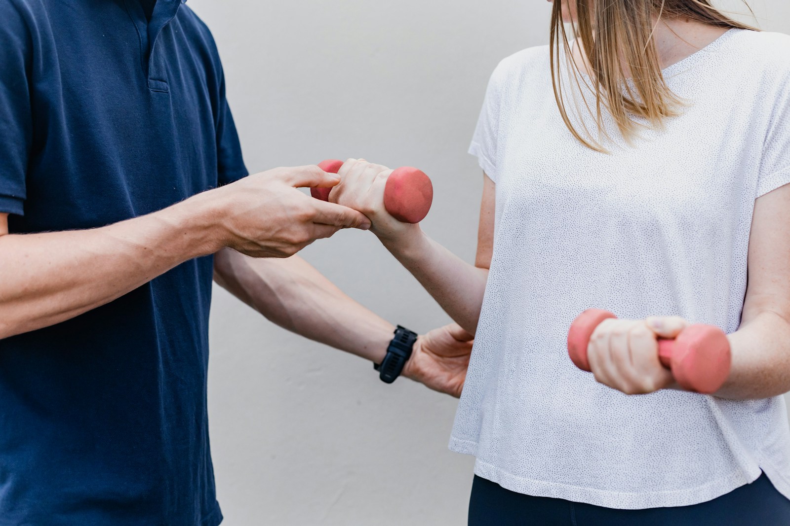 A practitioner guiding a controlled dumbbell exercise