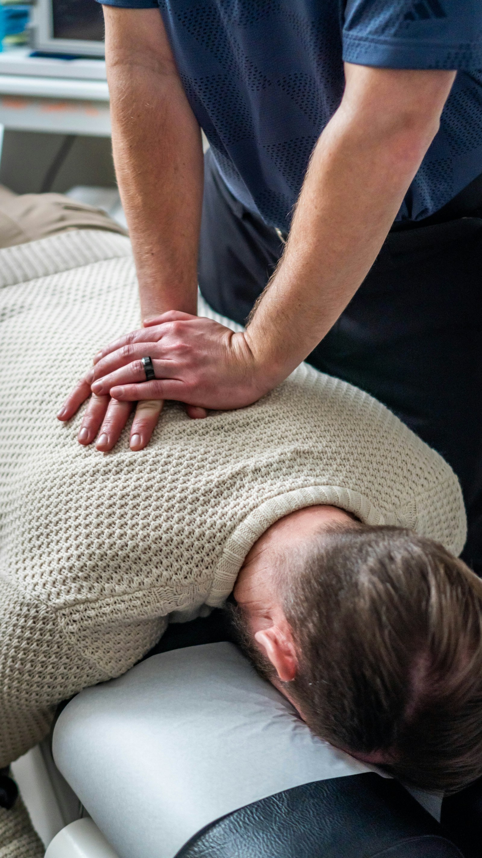 A practitioner applying a manual technique to the upper back