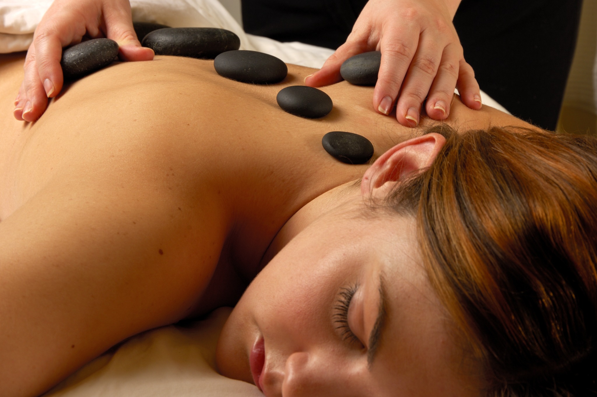 Warm massage stones positioned across the upper back during an Aroma Stone massage at Spa Lotus Darwin