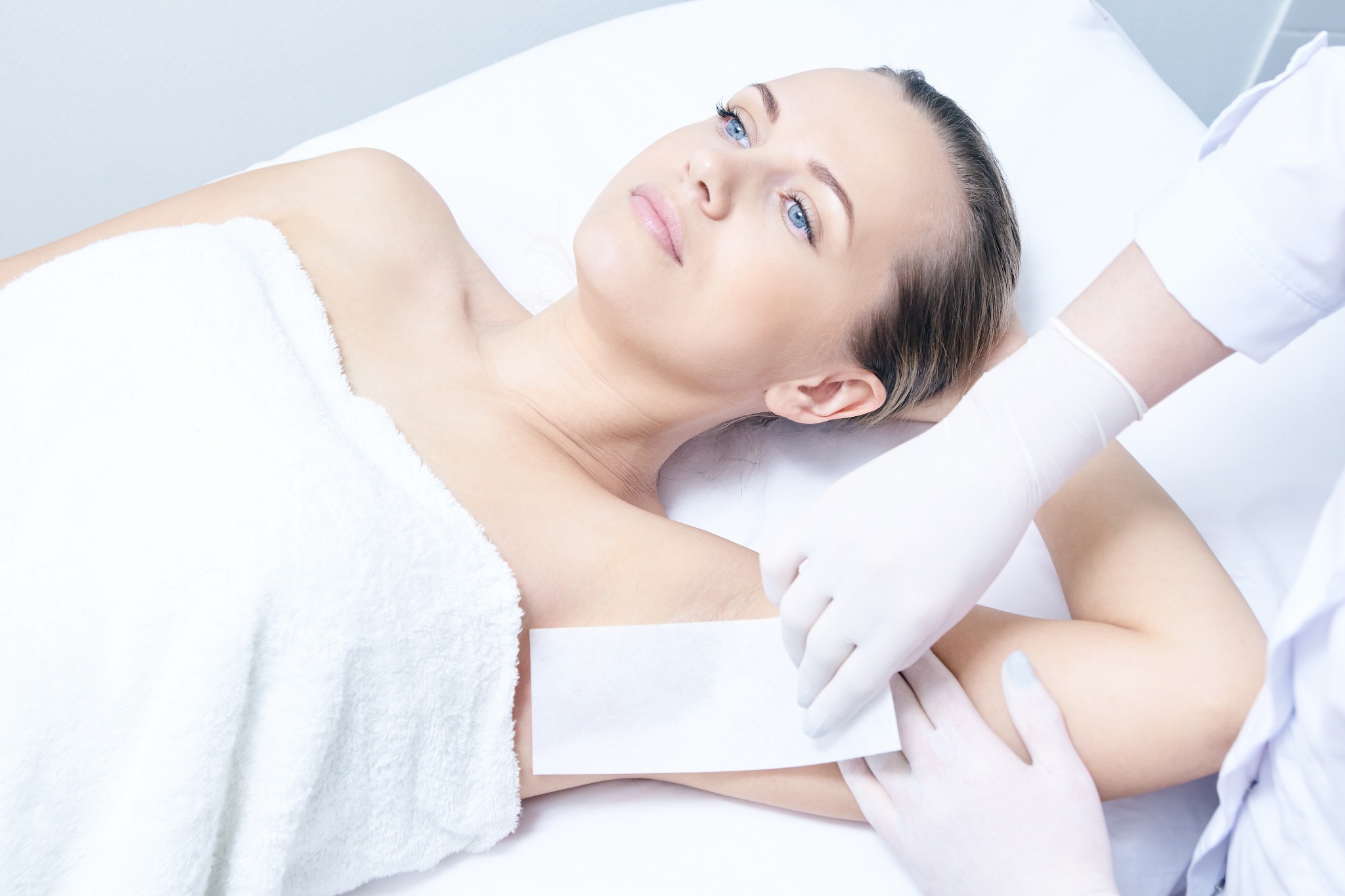 Professional underarm waxing treatment performed with hygienic technique